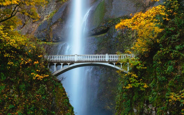 autumn landscape with waterfall and stone bridge
